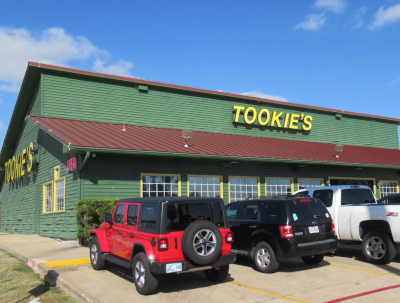 Picture of front of restaurant that says Tookies. Also cars parked